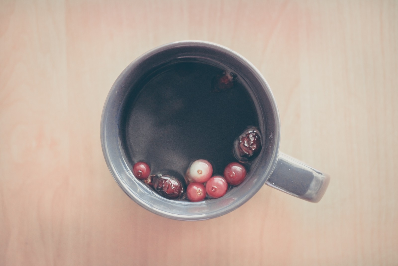 Cup of Berry Blitz tea. Berries floating in the tea.